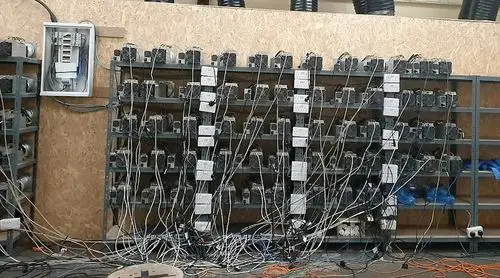 A mining farm with rows of mining rigs, showcasing the scale of operation and the importance of security and efficient cooling.